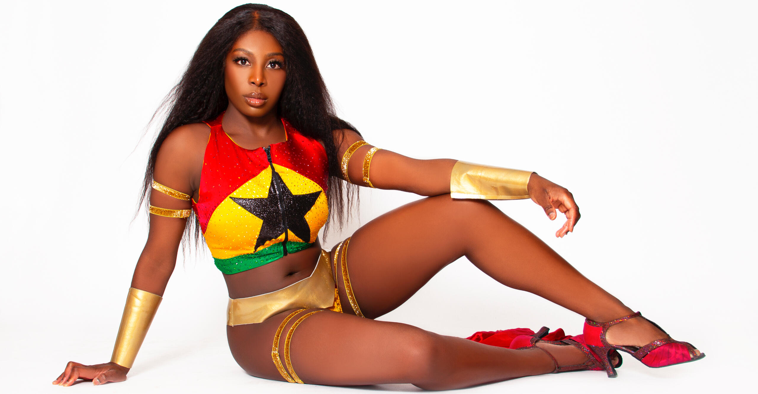 Toronto burlesque dancer Red Tongued Raven wearing a red, yellow and green costume.