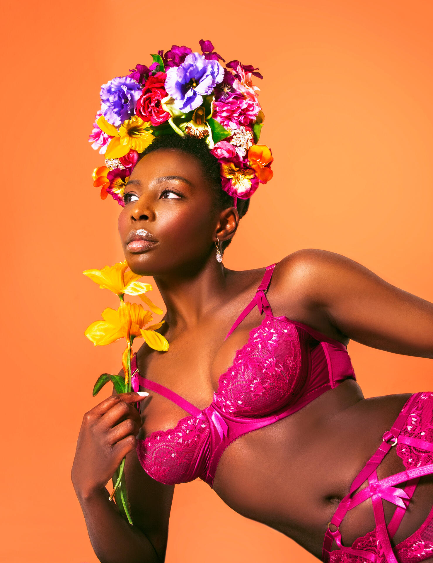 Red Tongued Raven wearing Dita Von Teese Magenta Madame X lingerie against orange background